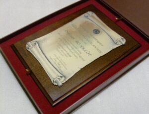 Dyplom w formie zwoju grawerowany w laminacie metalizowanym na desce dębowej w etui